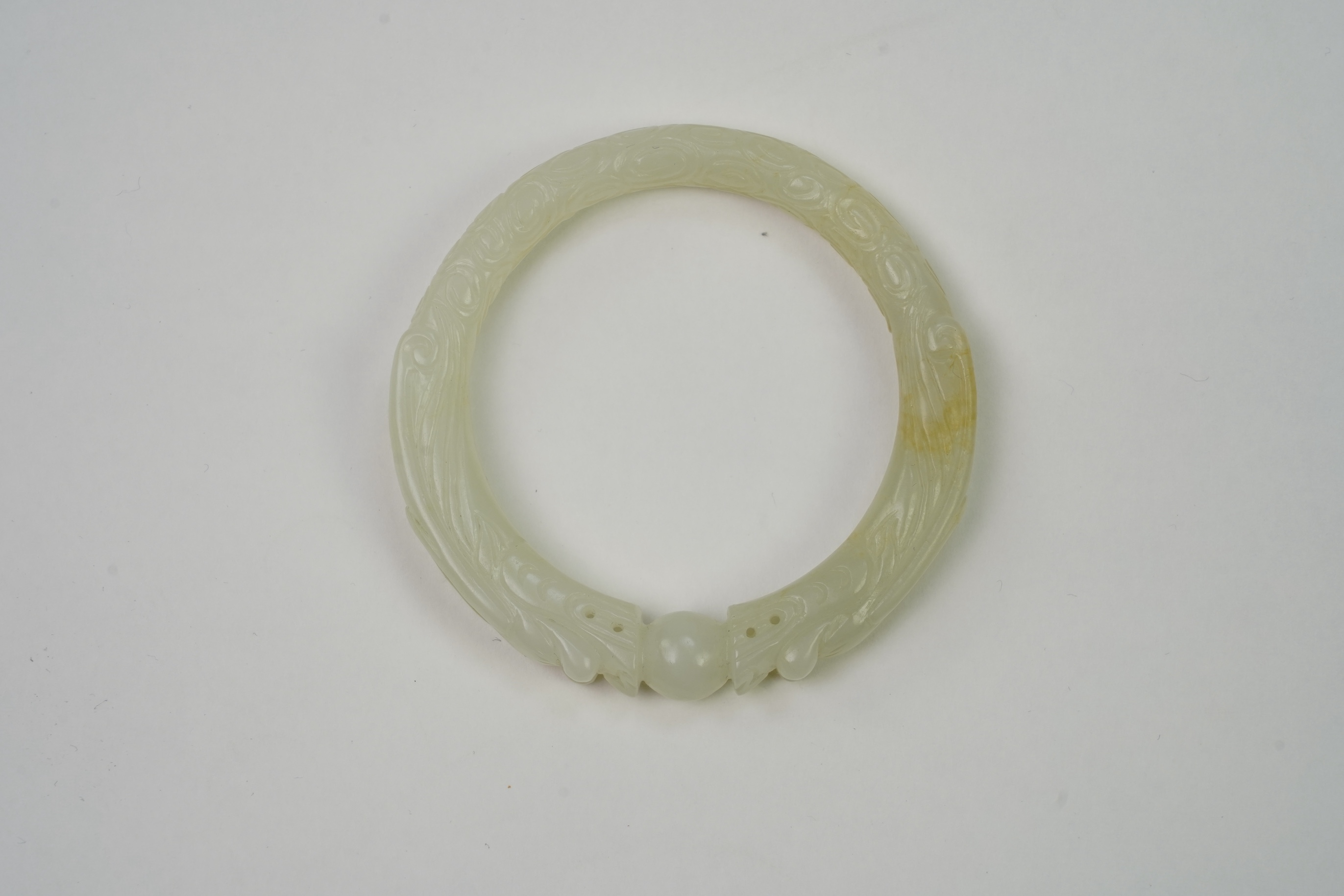 A Chinese pale celadon jade ’dragon’ bangle